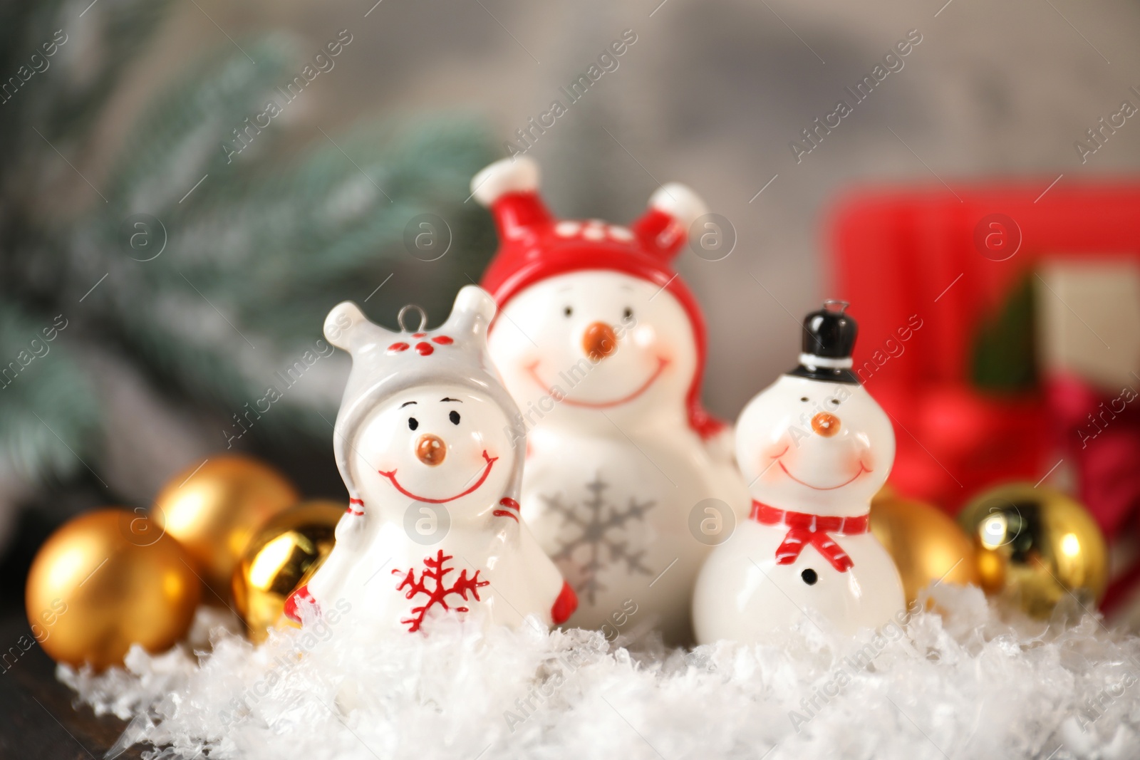 Photo of Funny snowmen figures and Christmas decor on table, closeup