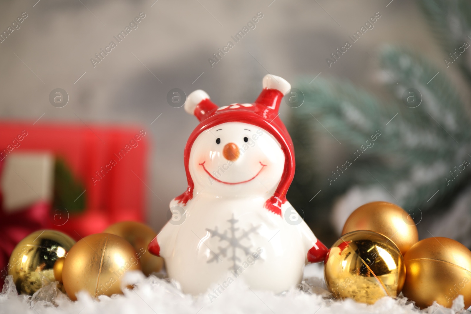 Photo of Funny snowman figure and Christmas decor on artificial snow, closeup