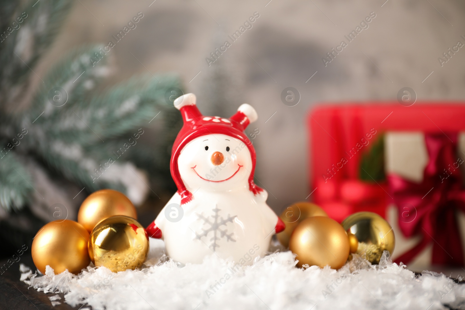 Photo of Funny snowman figure and Christmas decor on table, closeup