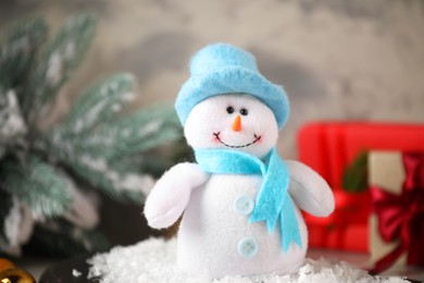 Photo of Funny snowman figure in hat on table, closeup