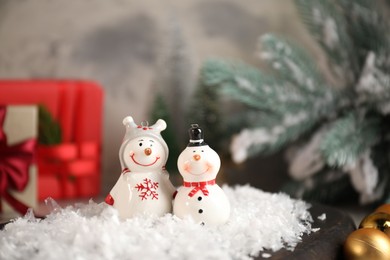 Photo of Funny snowmen figures and Christmas decor on table