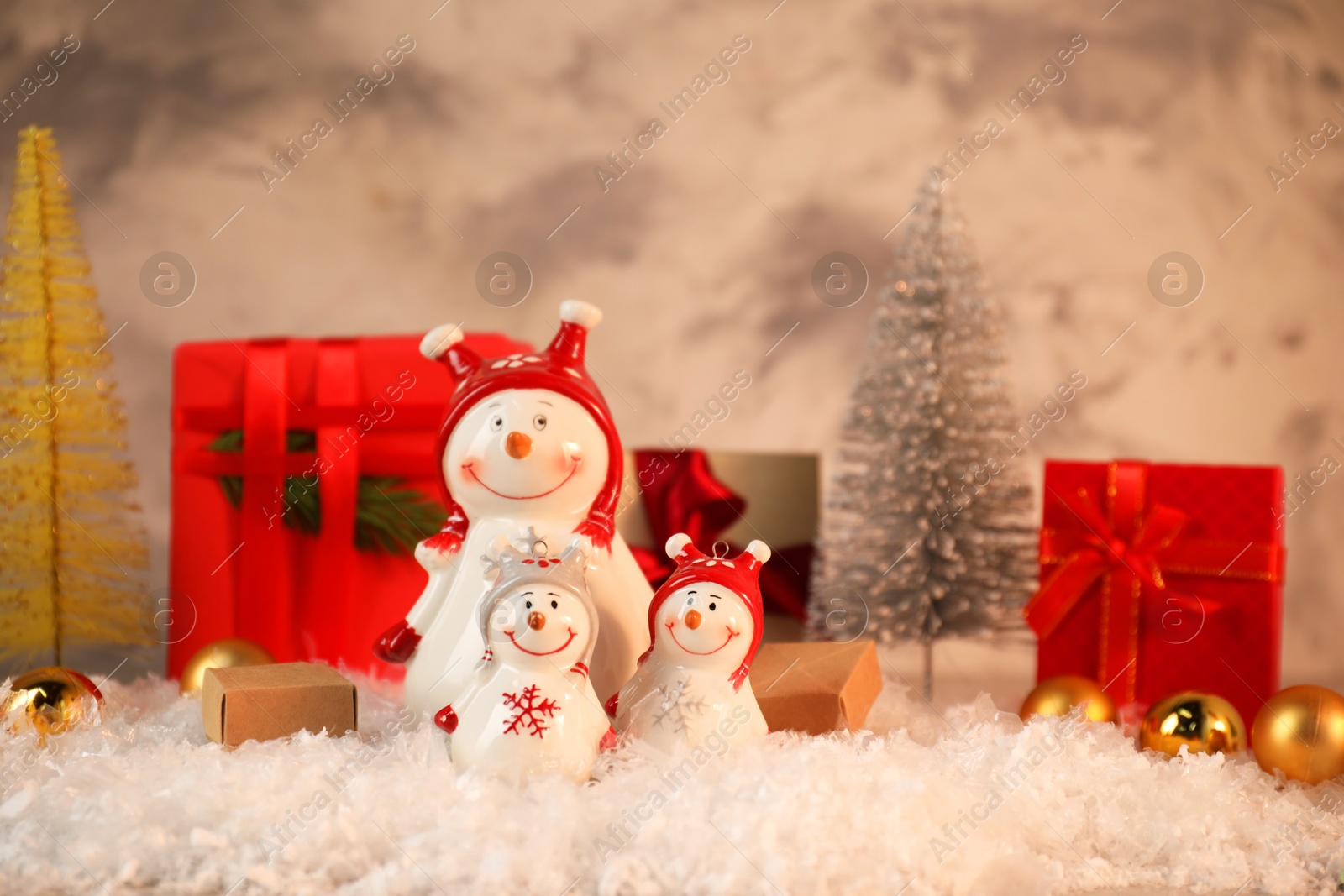 Photo of Funny snowmen figures and Christmas decor on artificial snow