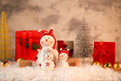 Photo of Funny snowmen figures and Christmas decor on artificial snow