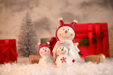 Photo of Funny snowmen figures and Christmas decor on artificial snow