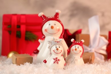 Photo of Funny snowmen figures and Christmas decor on artificial snow