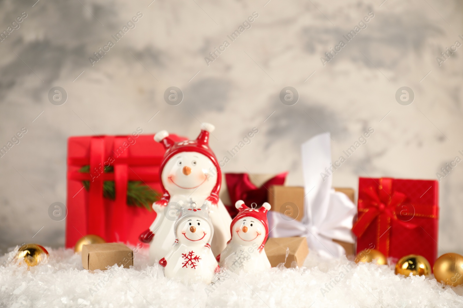 Photo of Funny snowmen figures and Christmas decor on artificial snow