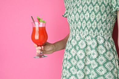 Photo of Woman with glass of refreshing cocktail on pink background, closeup