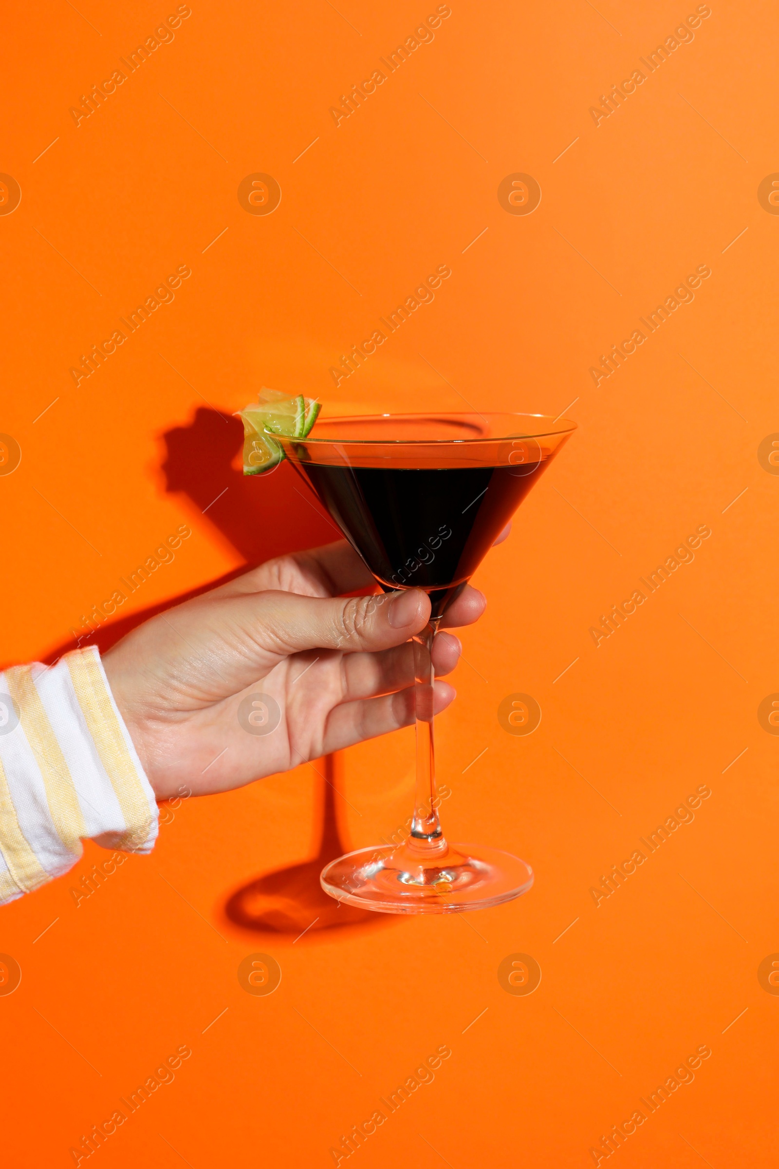 Photo of Woman with glass of refreshing cocktail on orange background, closeup