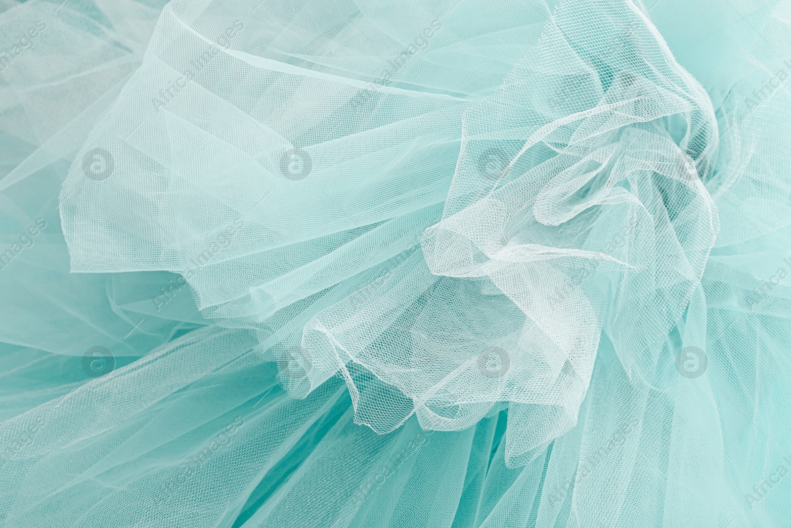 Image of Beautiful white color tulle on turquoise background, closeup view of fabric