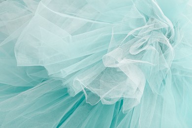 Image of Beautiful white color tulle on turquoise background, closeup view of fabric