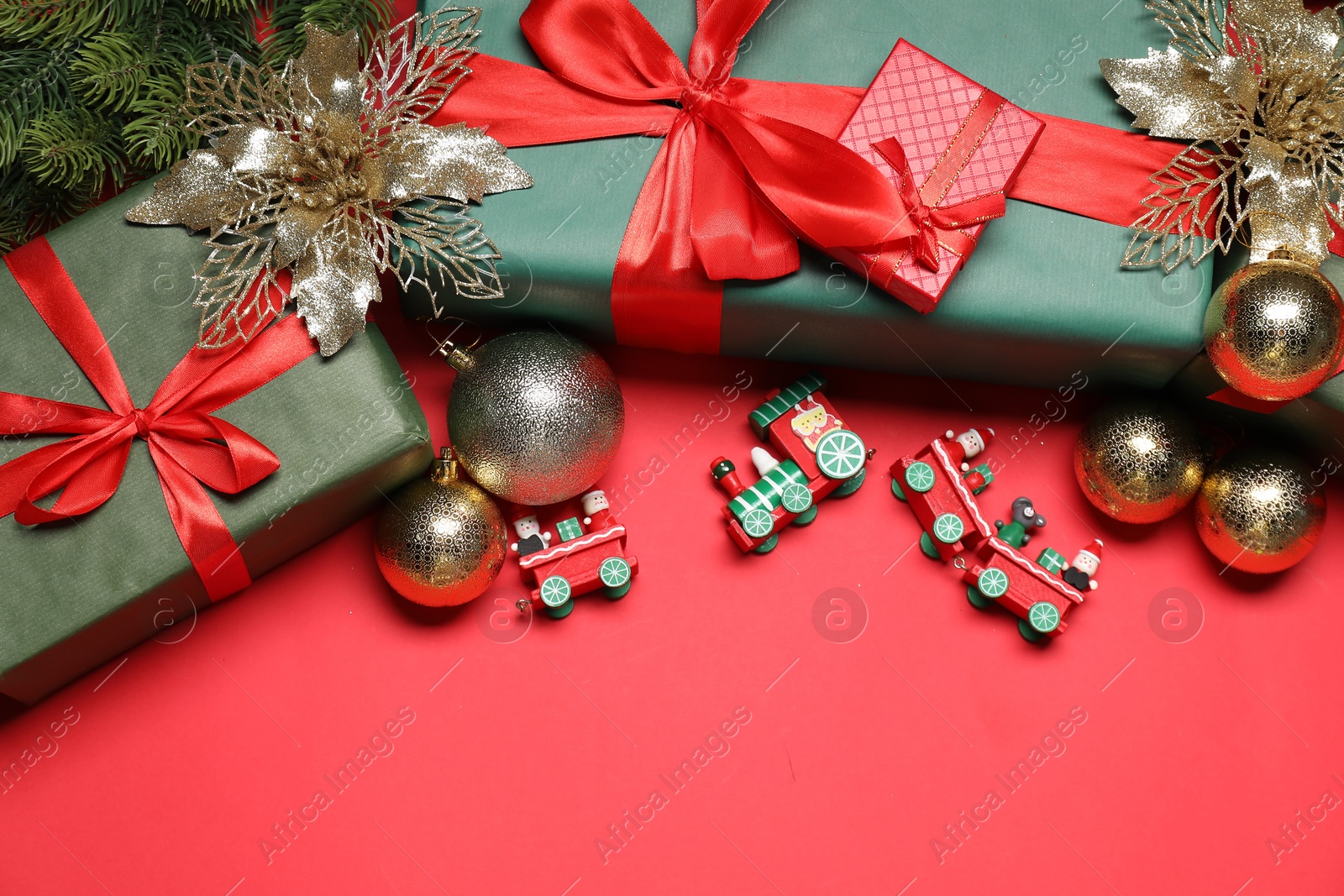 Photo of Christmas composition with festive decor on red table, above view. Space for text