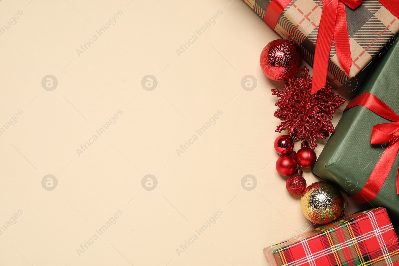 Photo of Different Christmas decor and gift boxes on beige background, flat lay. Space for text