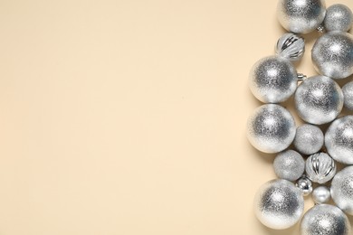 Photo of Shiny baubles on beige background, top view. Space for text