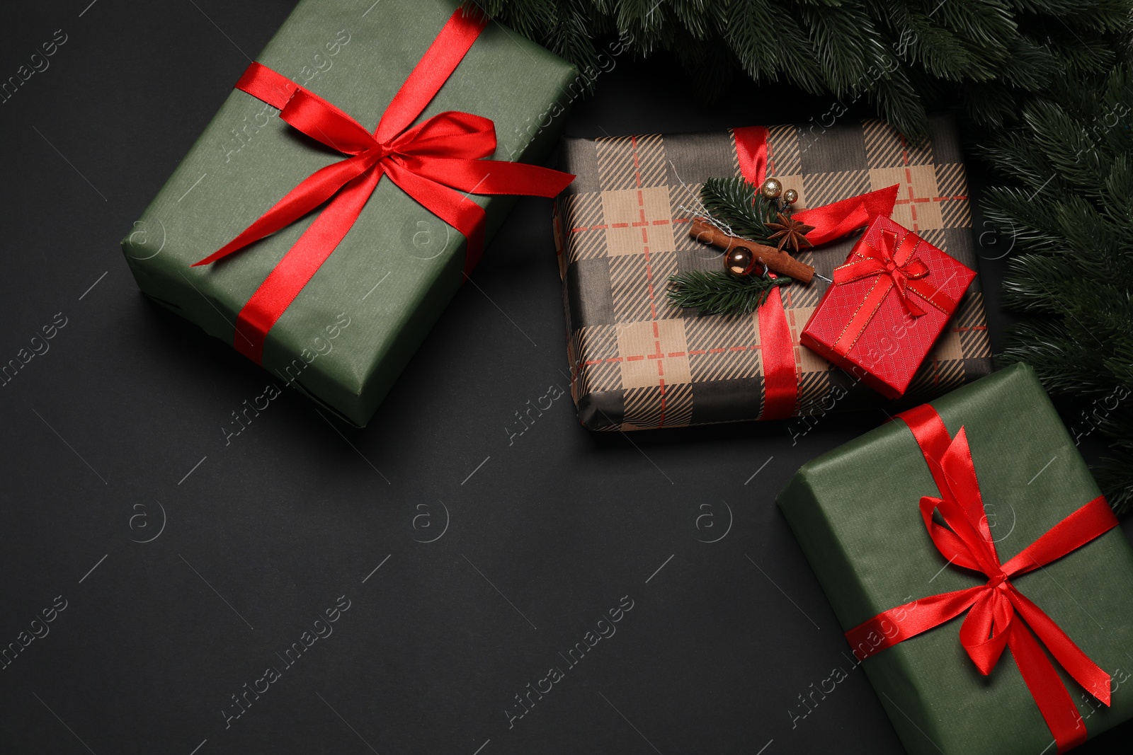 Photo of Christmas decor and gift boxes on black background, flat lay. Space for text