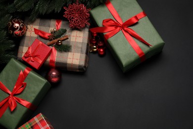 Photo of Christmas decor and gift boxes on black background, flat lay. Space for text