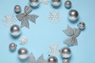 Photo of Frame of different Christmas decor on light blue background, flat lay. Space for text