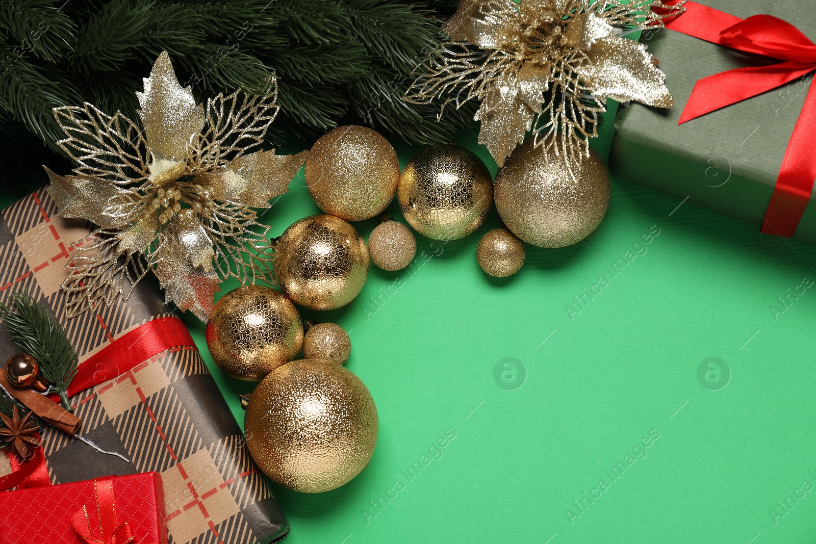 Photo of Different Christmas decor and gift boxes on green background, flat lay. Space for text