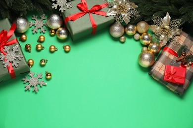 Photo of Different Christmas decor and gift boxes on green background, flat lay. Space for text