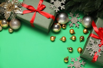 Photo of Different Christmas decor and gift boxes on green background, flat lay. Space for text