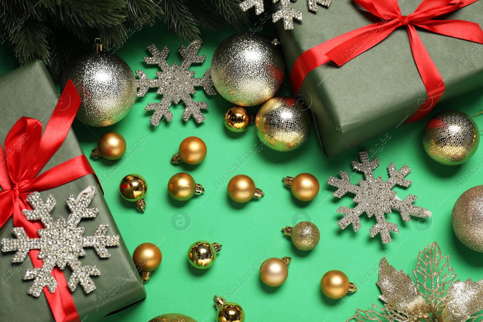 Photo of Different Christmas decor and gift boxes on green background, flat lay