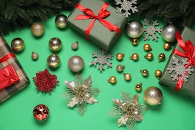 Photo of Different Christmas decor and gift boxes on green background, flat lay