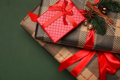 Photo of Different gift boxes on dark green background, top view. Space for text