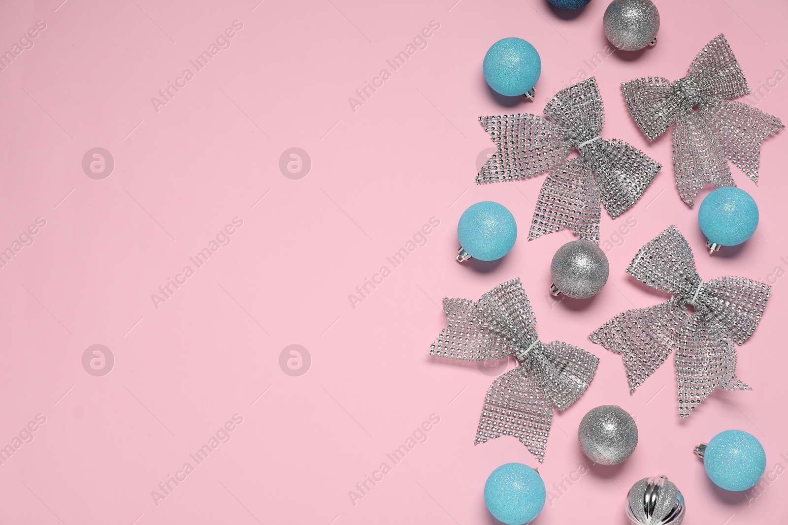 Photo of Flat lay composition with baubles and bows on pink background. Space for text