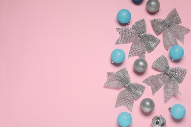 Photo of Flat lay composition with baubles and bows on pink background. Space for text