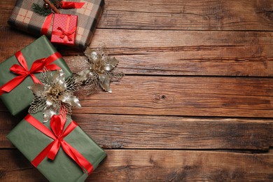 Photo of Different gift boxes and Christmas decor on wooden table, flat lay. Space for text