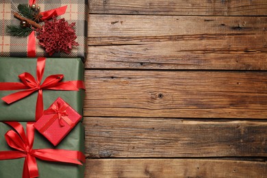 Photo of Different gift boxes and Christmas decor on wooden table, flat lay. Space for text