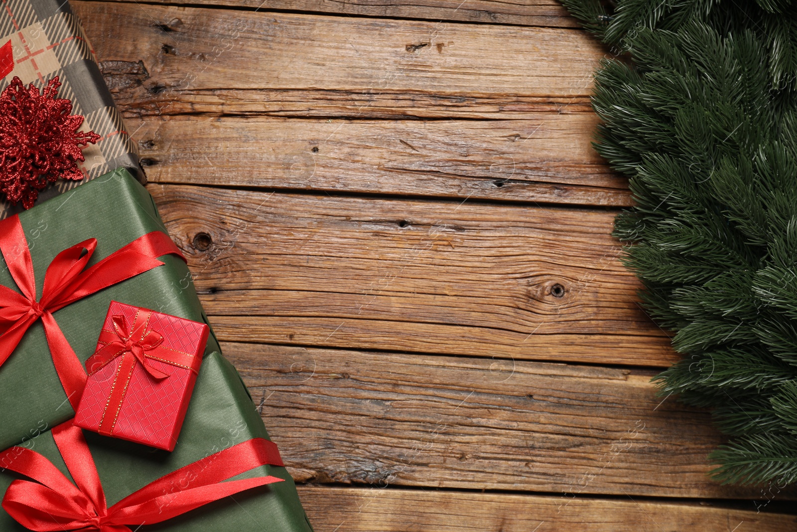 Photo of Different gift boxes and Christmas decor on wooden table, flat lay. Space for text