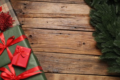 Photo of Different gift boxes and Christmas decor on wooden table, flat lay. Space for text