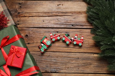 Different gift boxes and Christmas decor on wooden table, flat lay