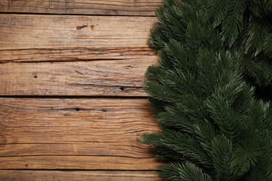 Photo of Fir tree branches on wooden table, top view. Space for text