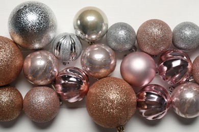 Photo of Different baubles on white wooden table, flat lay