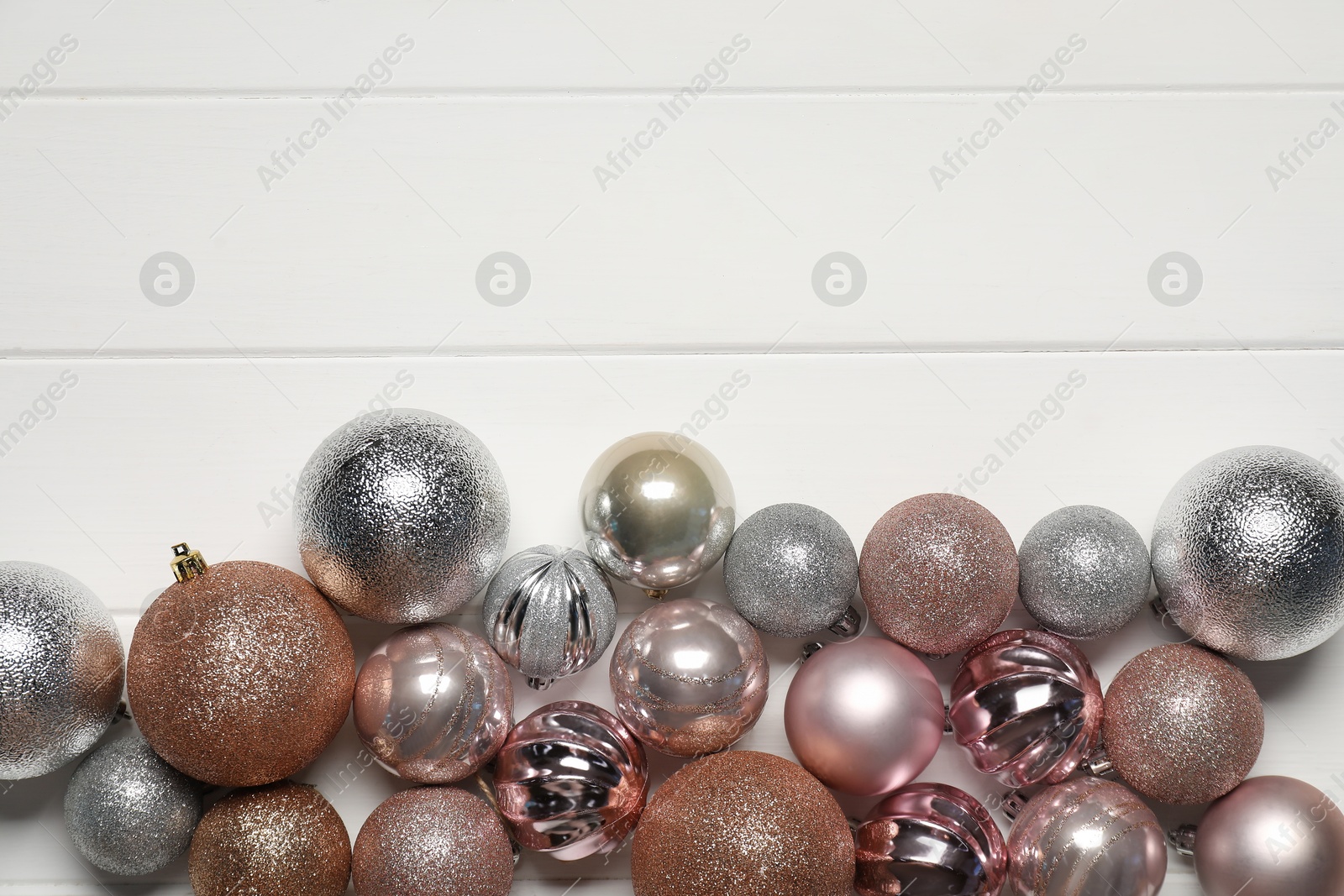 Photo of Different baubles on white wooden table, flat lay. Space for text