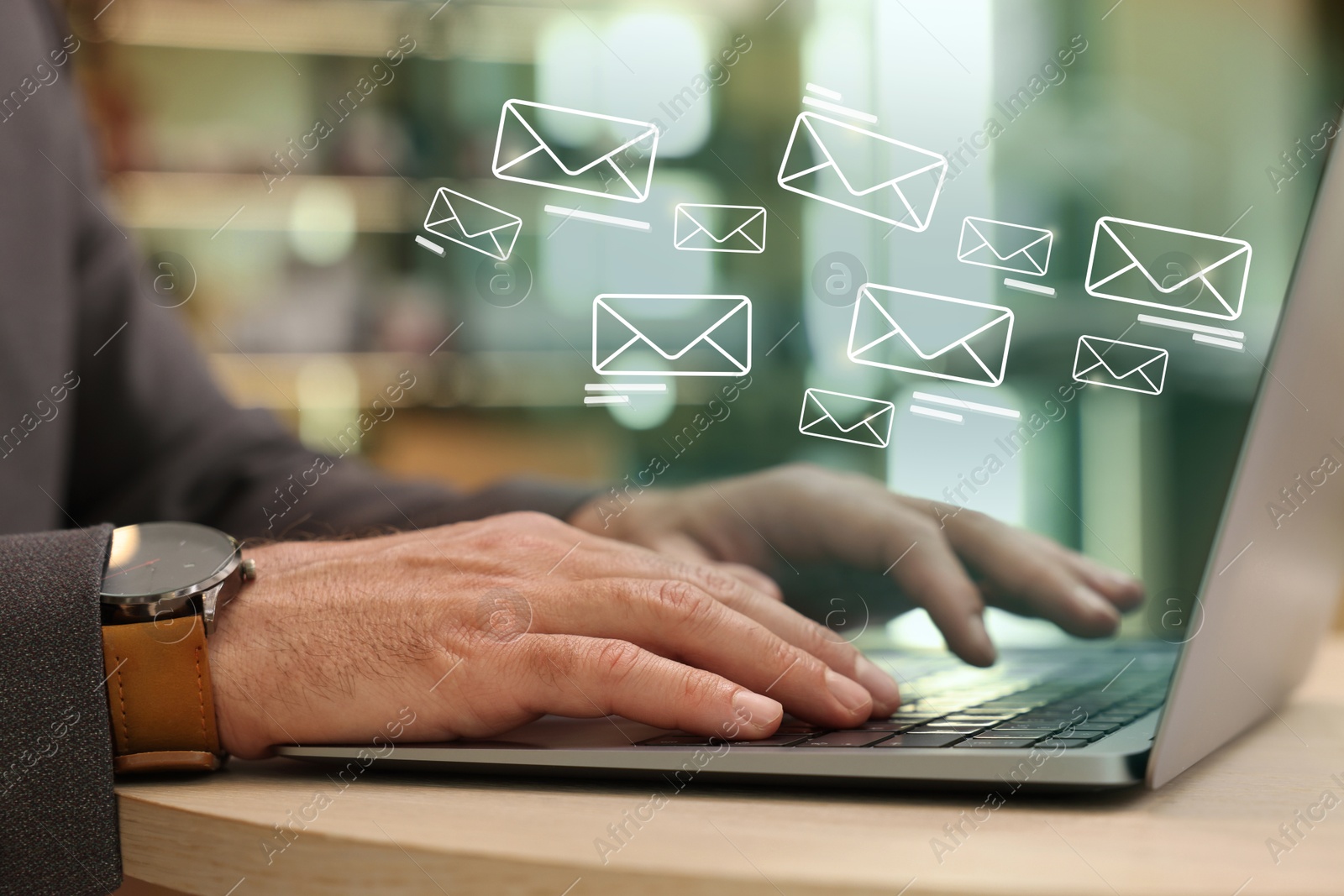 Image of Man using laptop at table, closeup. Illustrations of envelope over computer