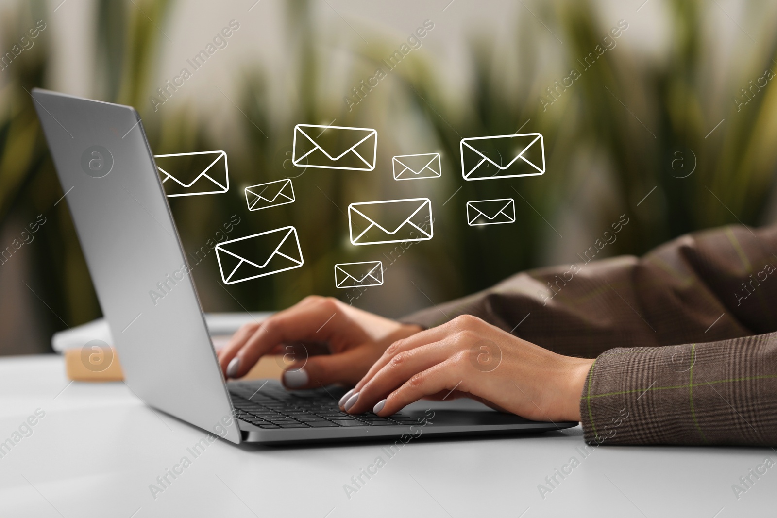 Image of Woman using laptop at table, closeup. Illustrations of envelope over computer