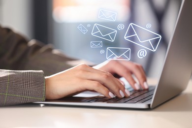 Image of Woman using laptop at table, closeup. E-mail address signs and envelopes over computer