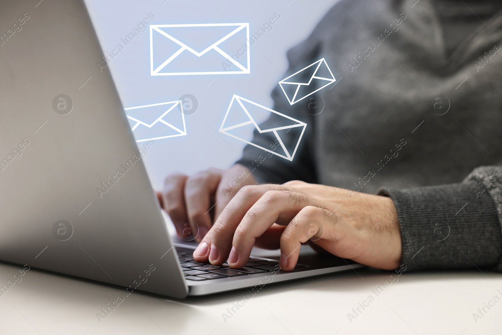 Image of Man using laptop at table, closeup. Illustrations of envelope over computer