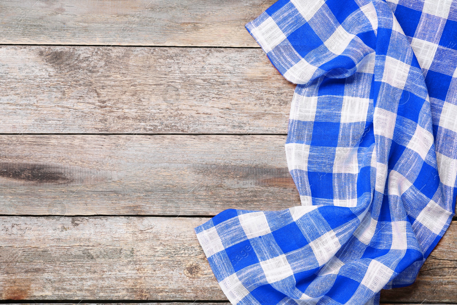 Image of Blue checkered gingham fabric on wooden table