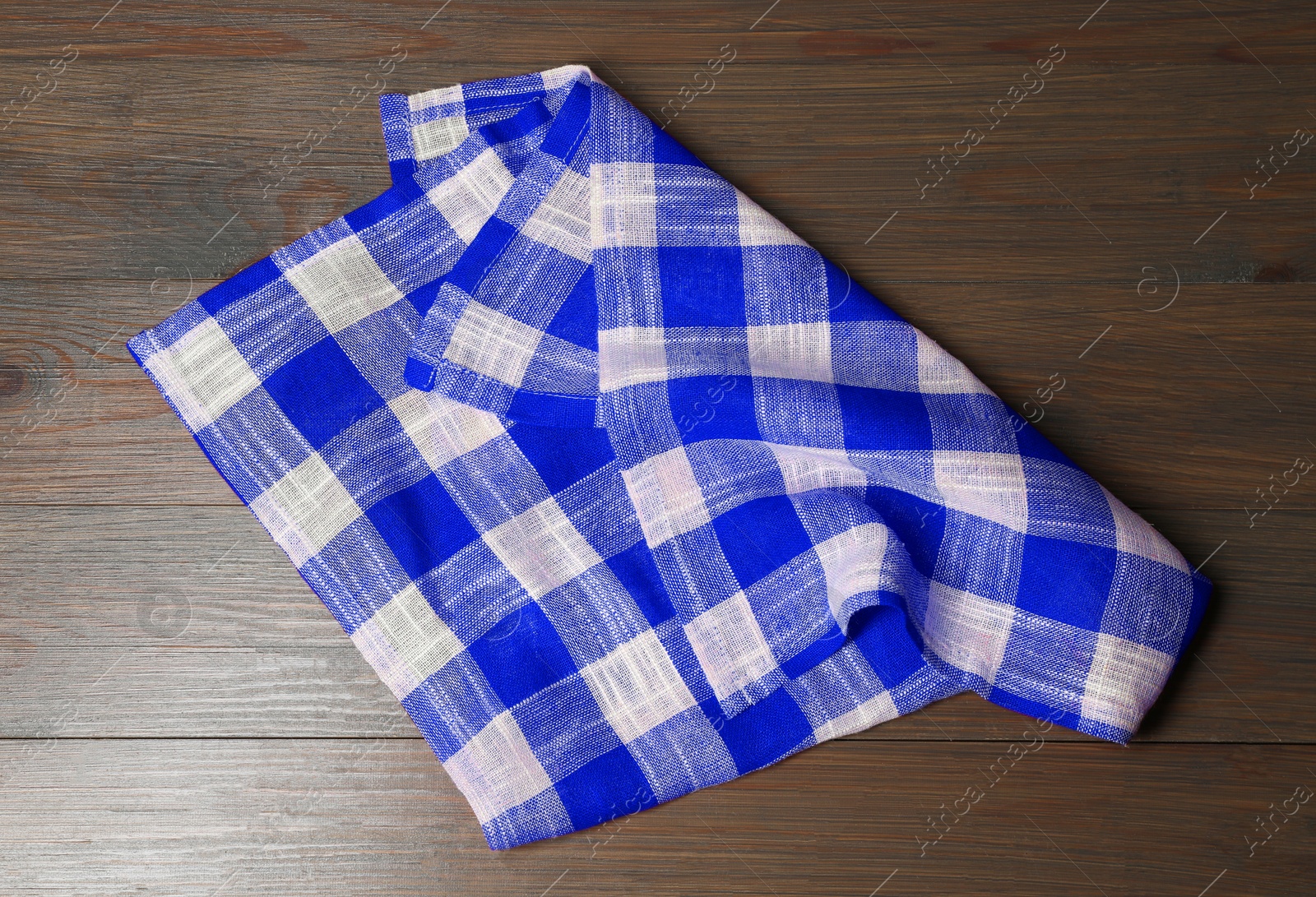 Image of Blue checkered gingham fabric on wooden table