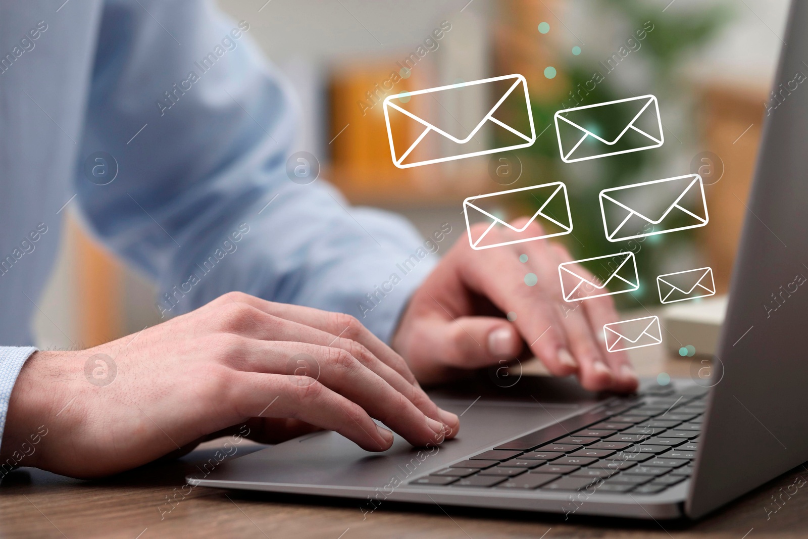 Image of Man using laptop at table, closeup. Illustrations of envelope over computer