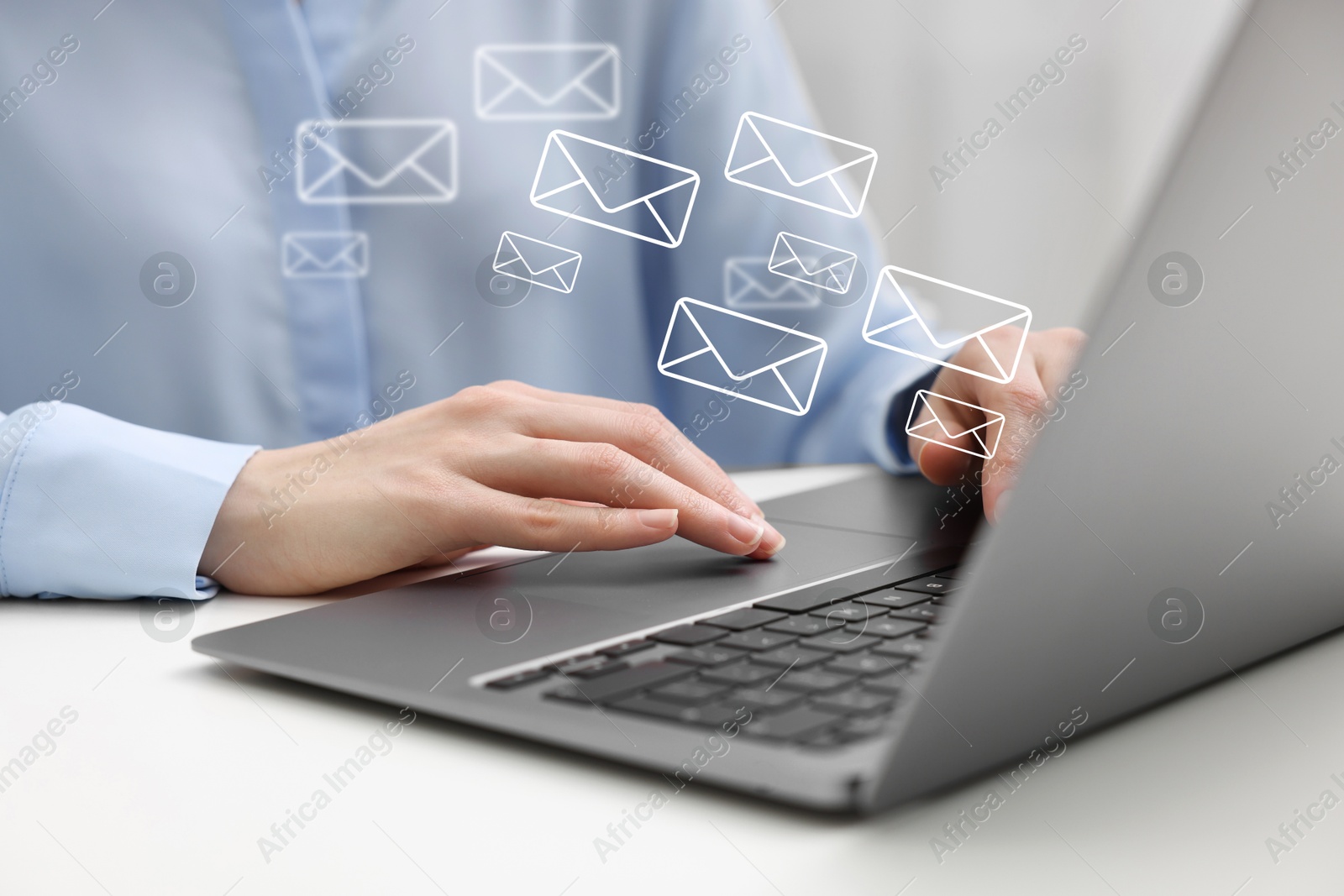 Image of Woman using laptop at table, closeup. Illustrations of envelope over computer