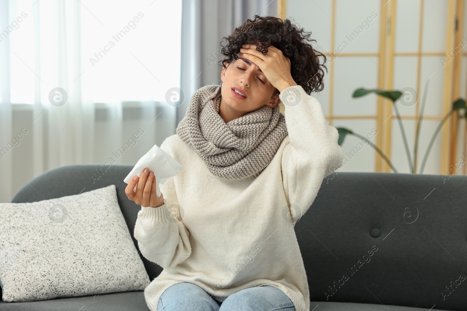 Photo of Cold symptom. Young woman with tissue at home