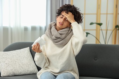 Photo of Cold symptom. Young woman with tissue at home