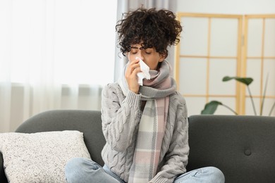 Cold symptom. Young woman with tissue at home