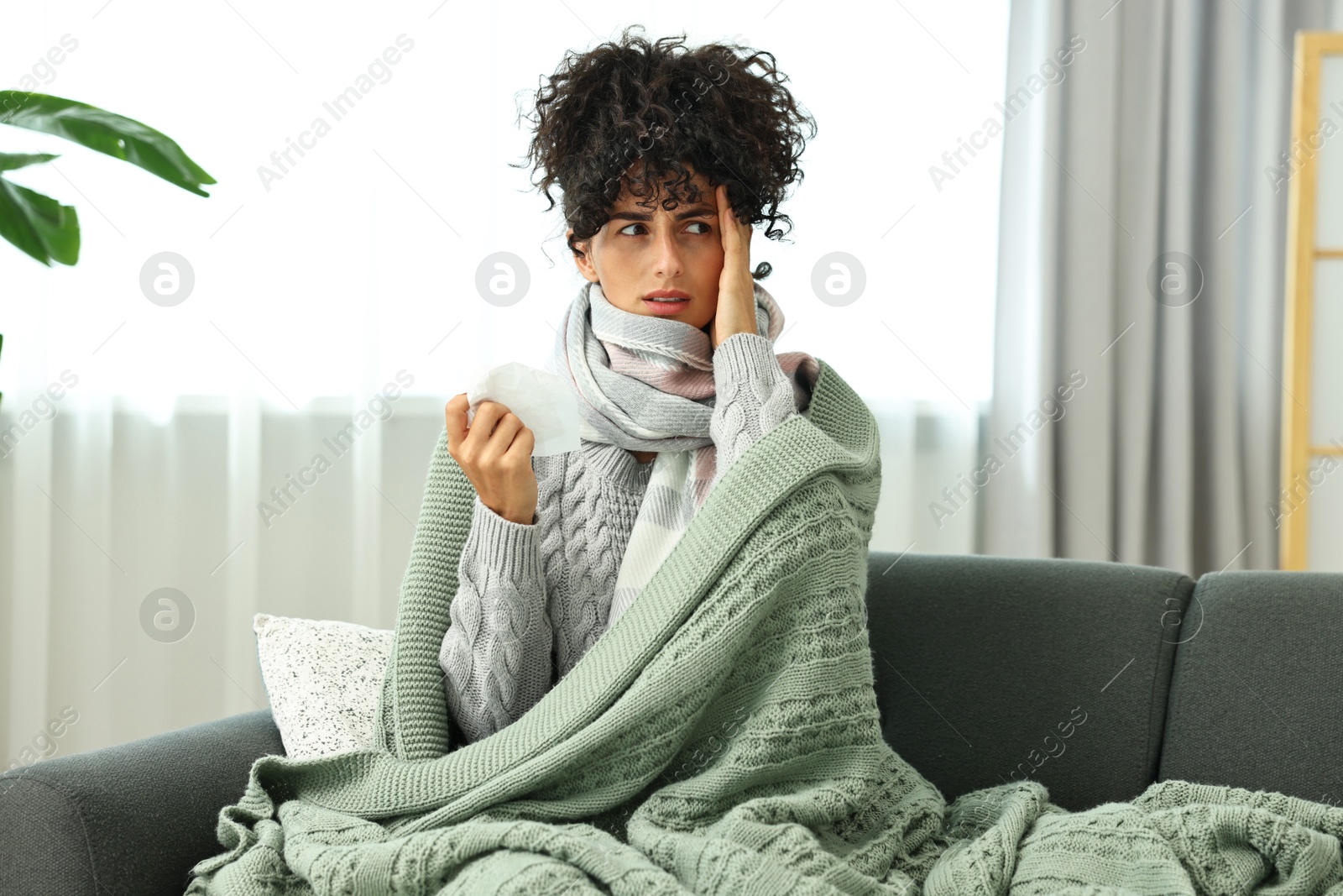 Photo of Cold symptom. Young woman with tissue at home