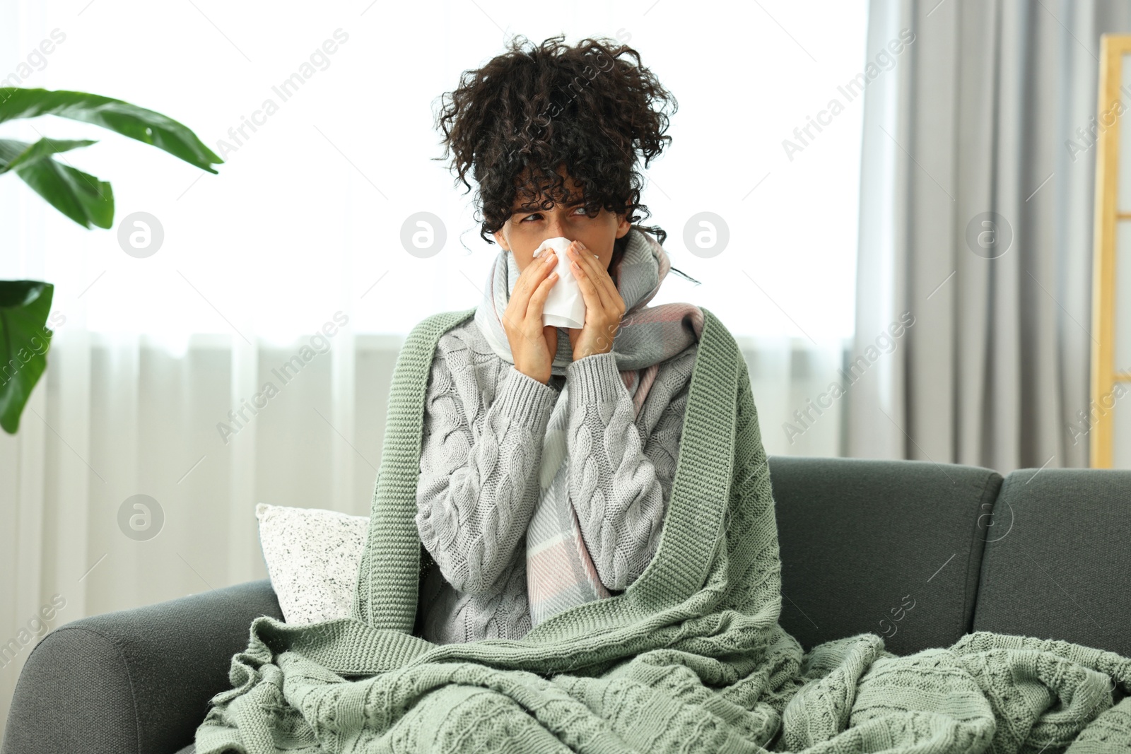 Photo of Cold symptom. Young woman with tissue at home