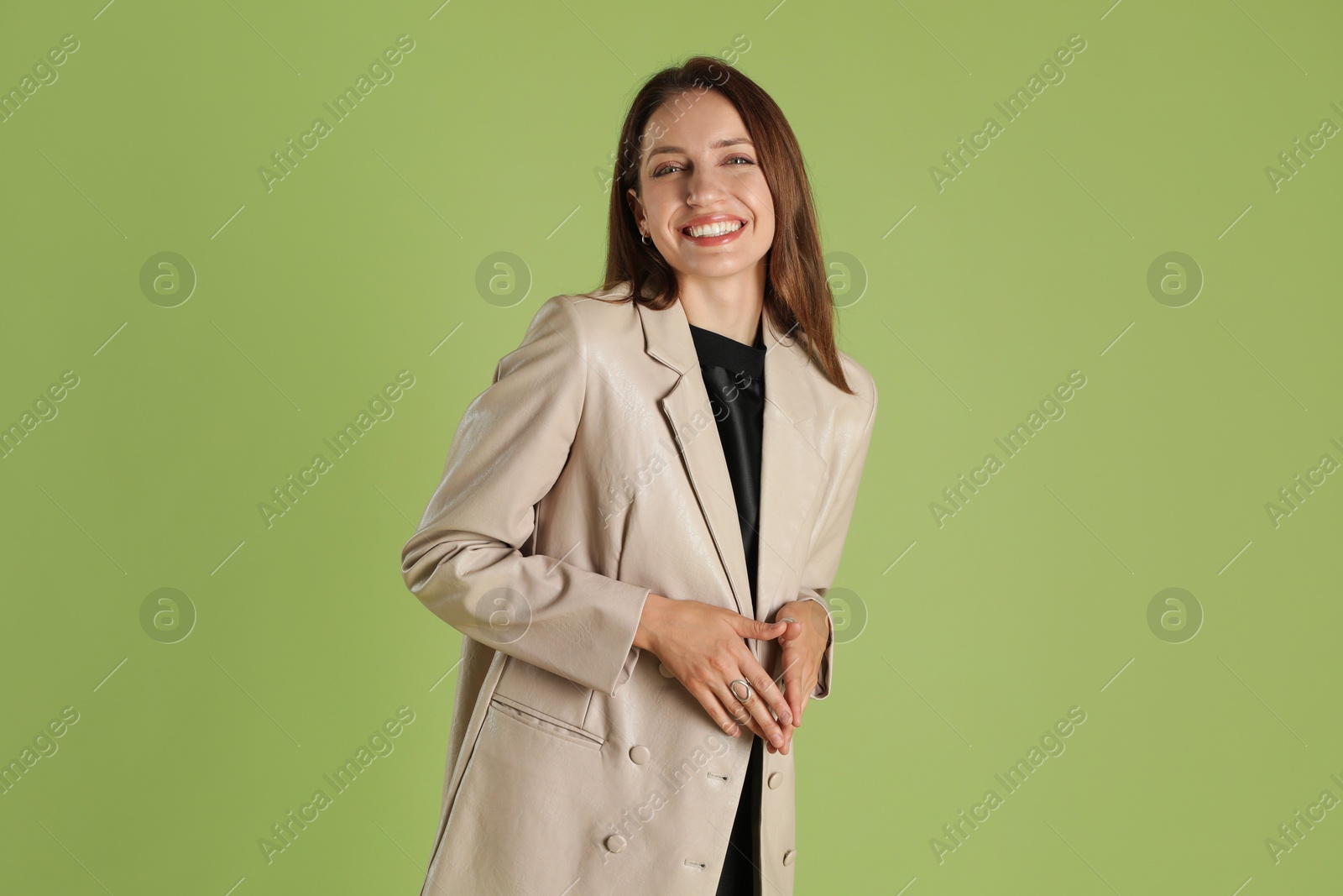 Photo of Beautiful woman in stylish beige jacket on olive background